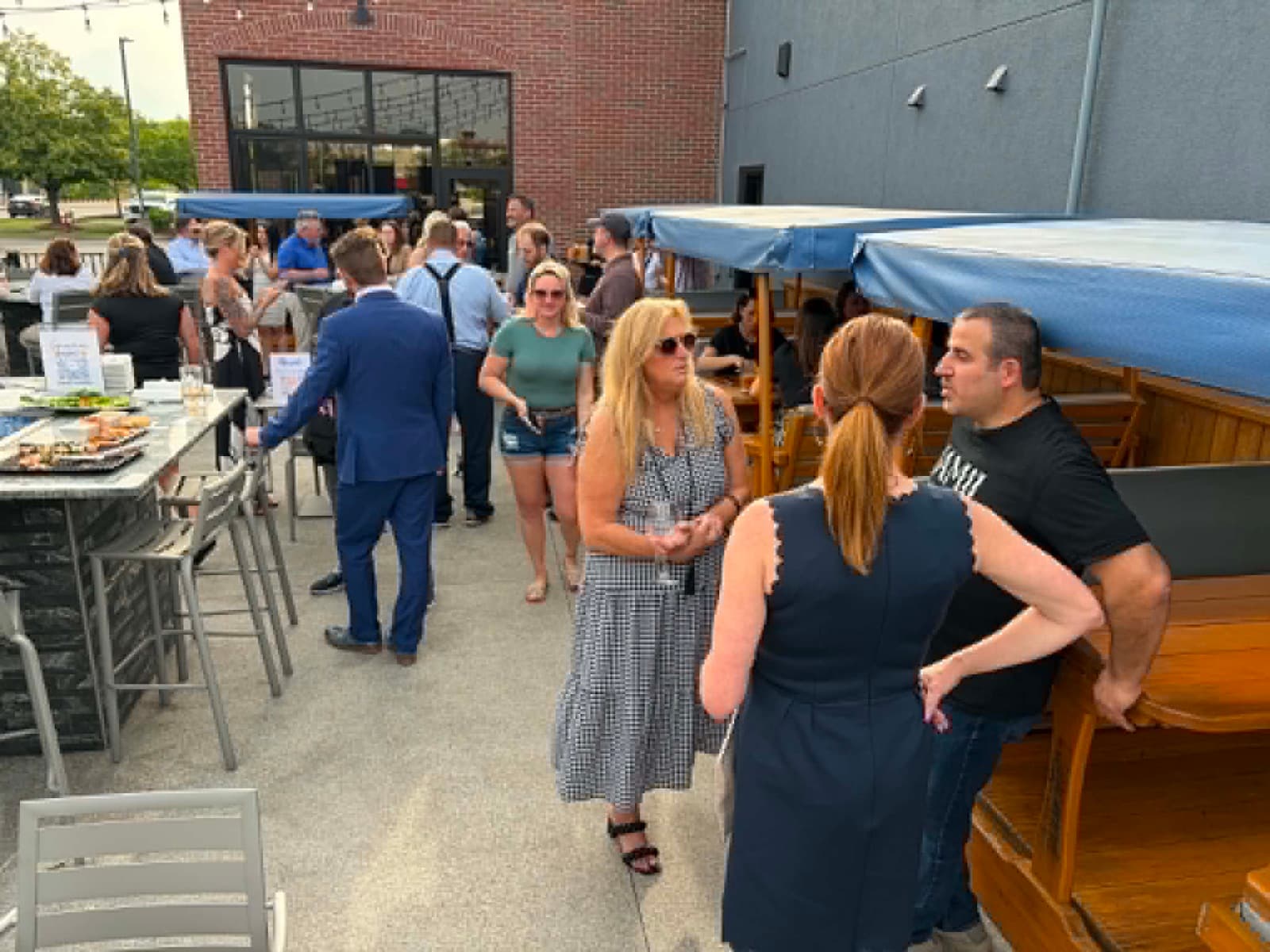 Members mingling on a packed patio at an Impact networking event
